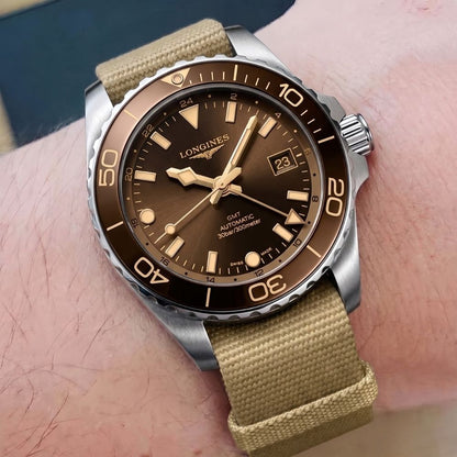 Longines HydroConquest GMT quadrante marrone indossato al polso, foto lifestyle primo piano con cinturino in tessuto beige