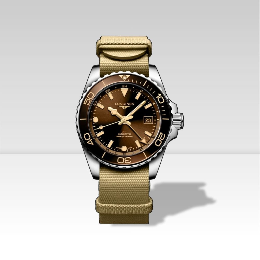 Longines HydroConquest GMT quadrante marrone bronzo, cinturino NATO in tessuto beige, vista frontale su sfondo neutro