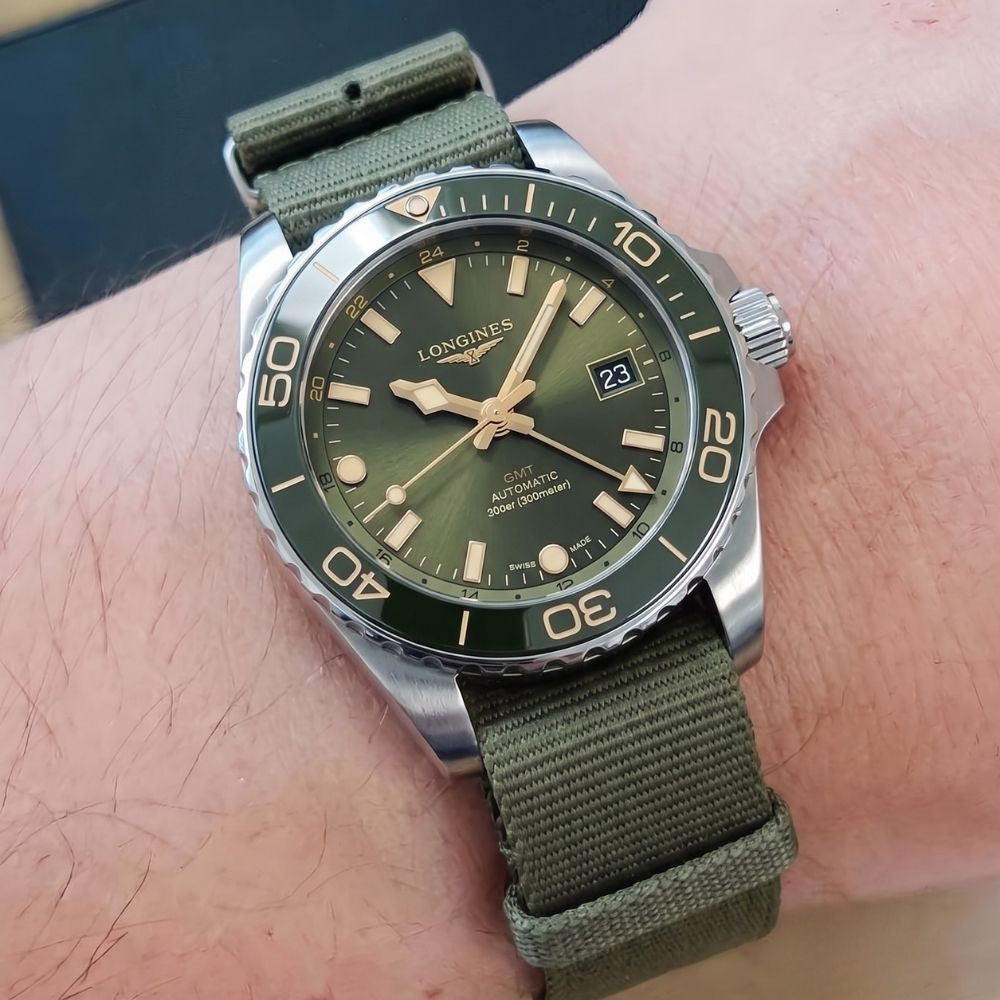 Longines HydroConquest GMT quadrante verde indossato al polso, foto lifestyle primo piano con cinturino in tessuto